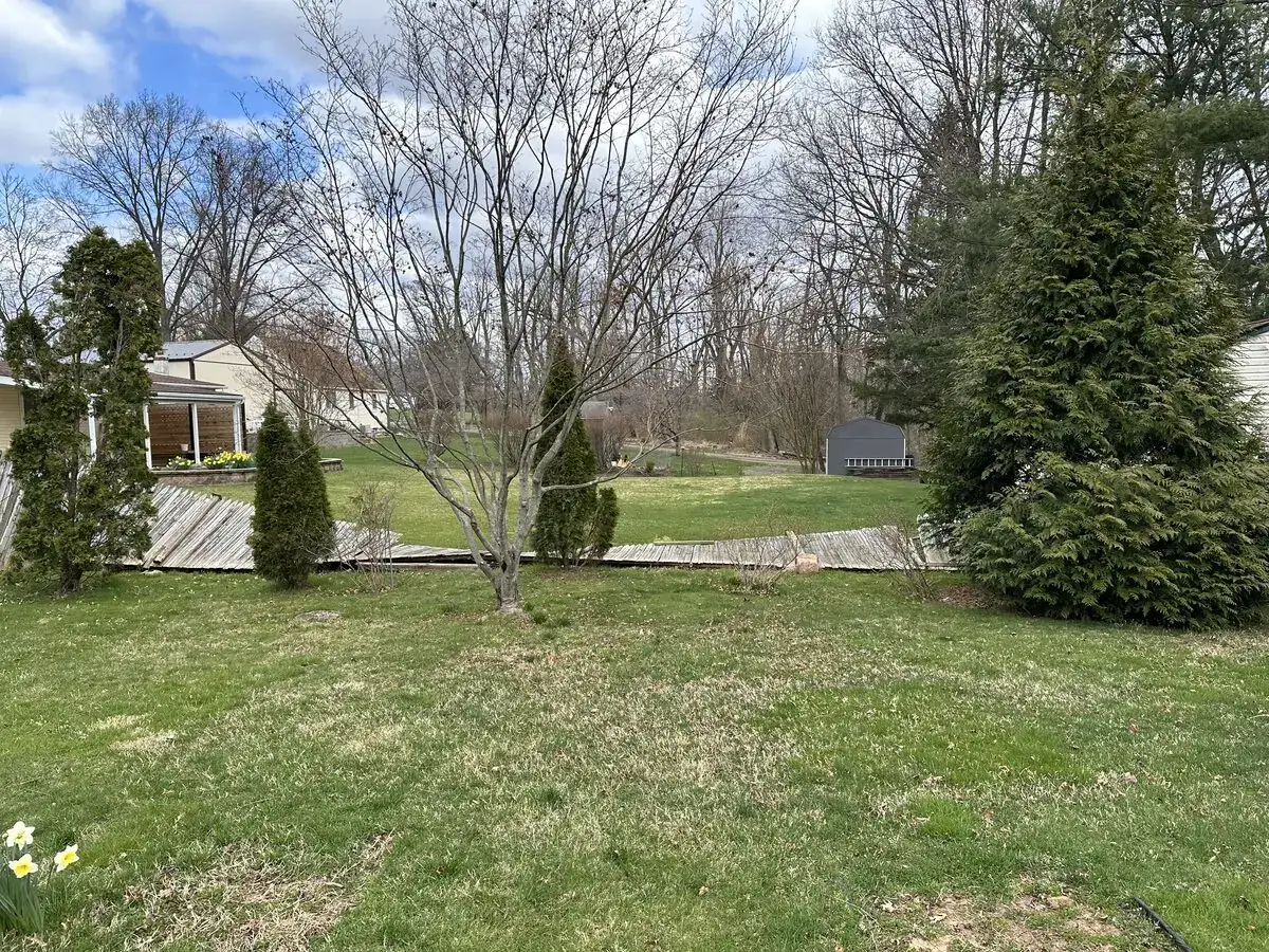 Backyard before fence replacement, showing an aging wood fence leaning along the property line.